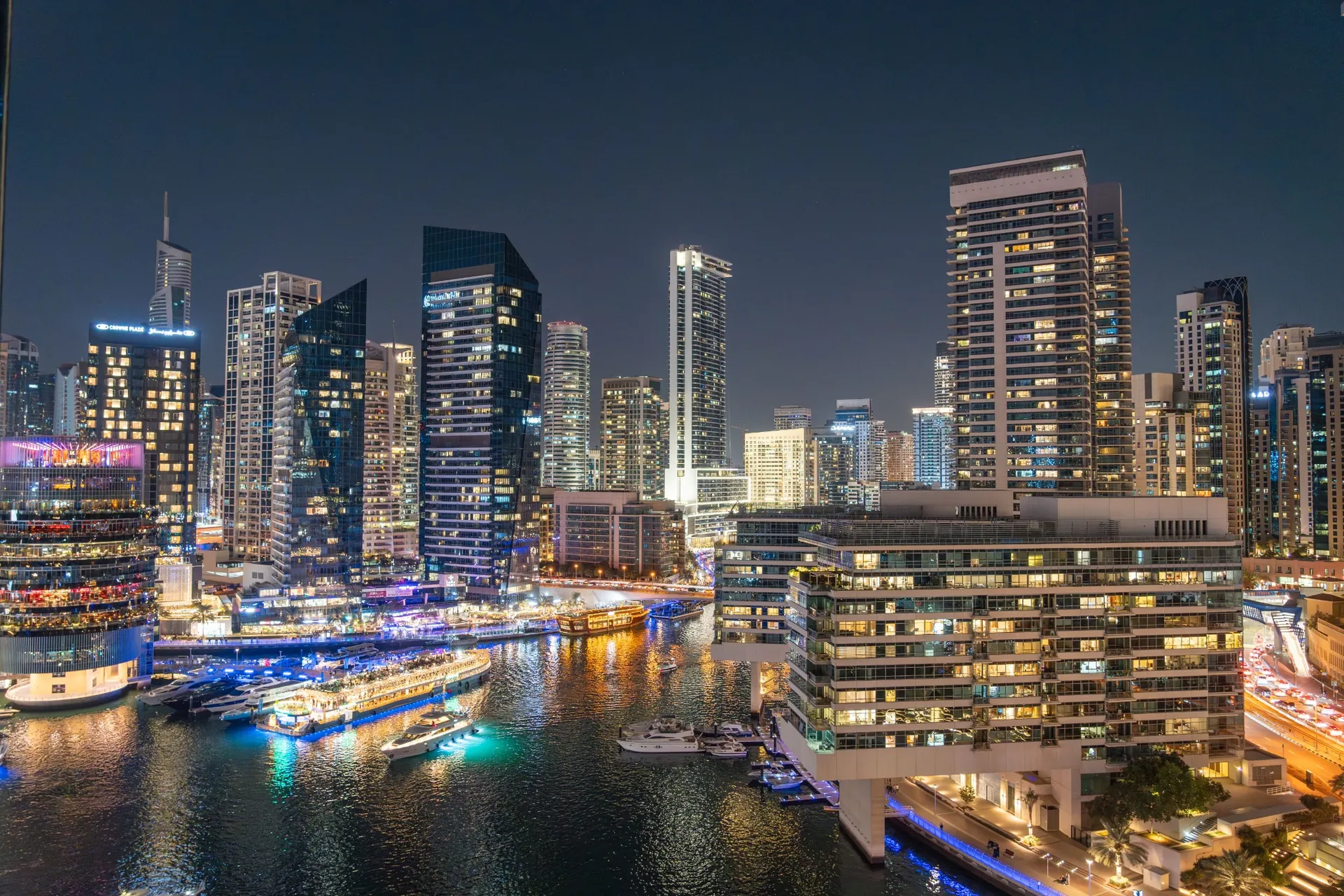 Illuminated skyscrapers reflected in Dubai Marina at night